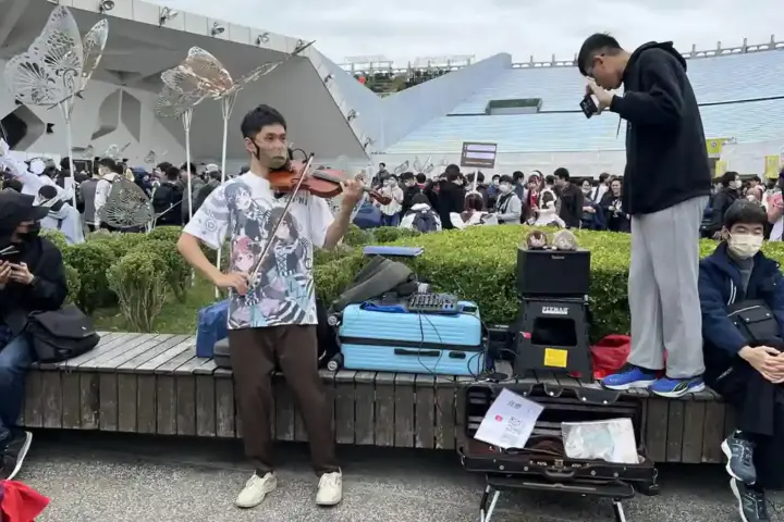 Person using smartphone to record video content, holding phone steady while capturing another activity