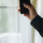 A person holding and using a smartphone in their hands
