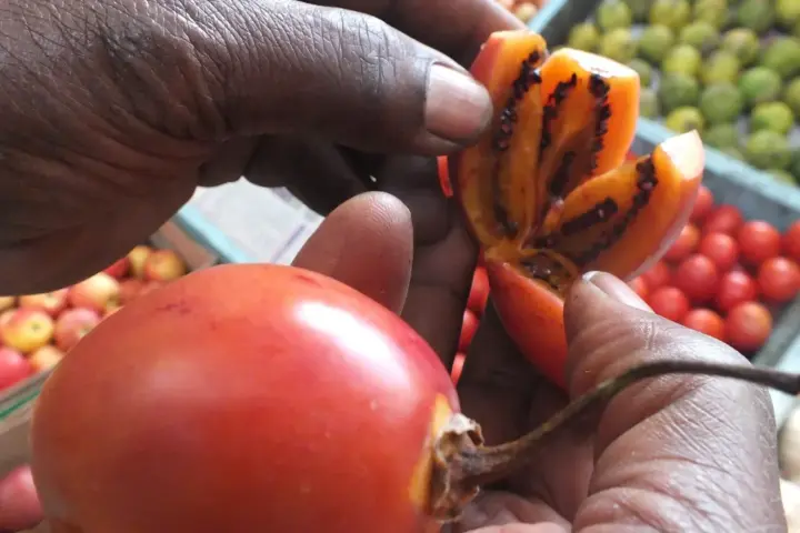 Several red tamarillo fruits, also called tree tomatoes, on a plate.